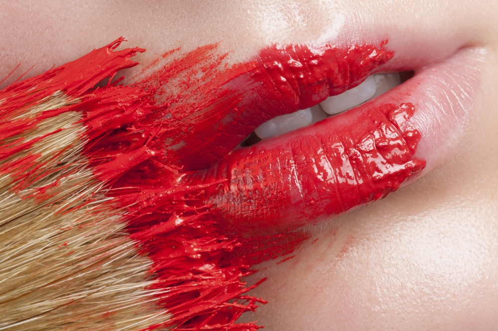 Paint Brushing a Woman's Lips Red