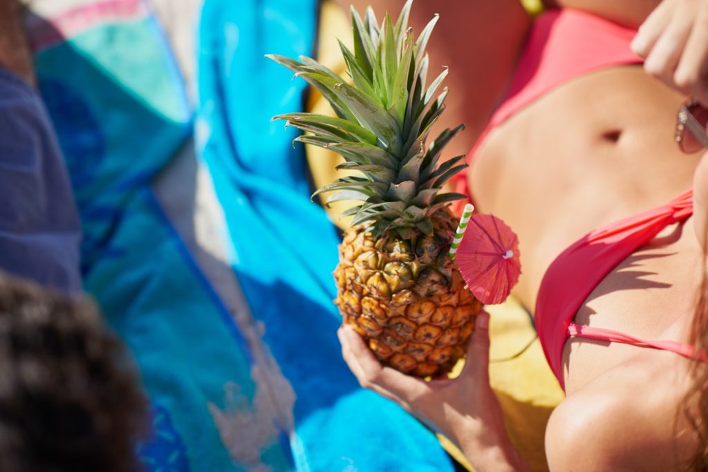 Woman in Bikini Enjoying Pineapple Drink